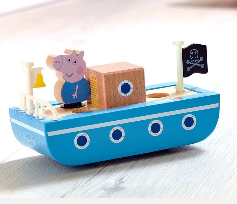 Blå lekebåt med grisefigur og piratflagg.