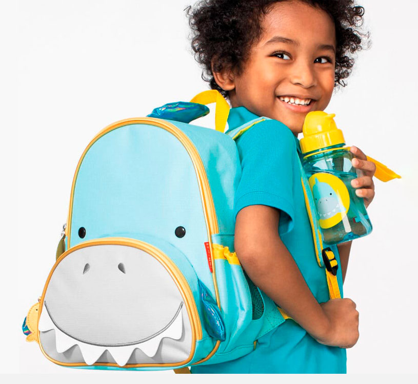 Barn med blå dinosaursekk og matchende drikkeflaske.