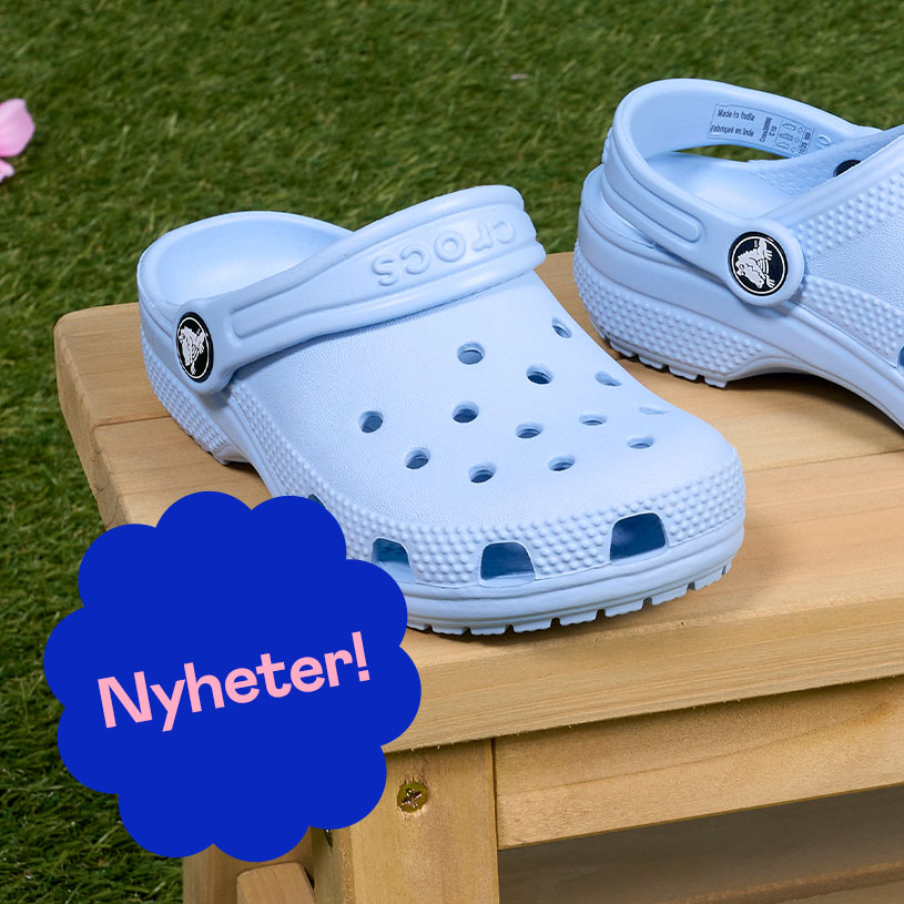 To personer med fargerike crocs og sokker utendørs. "Nyhet!"-boble.