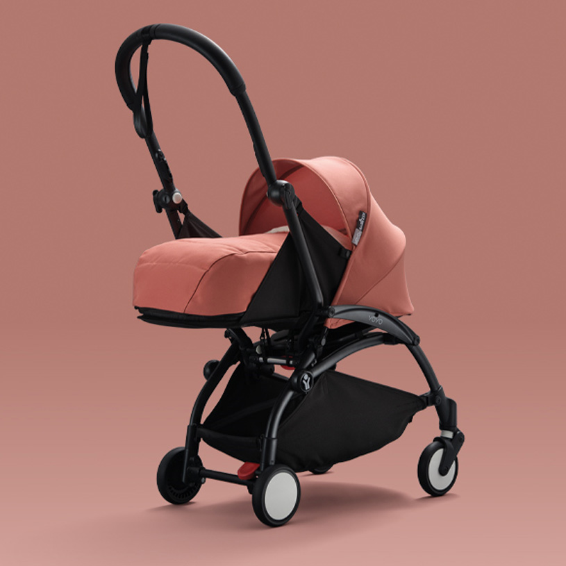 Rosa barnevogn mot rosa bakgrunn.