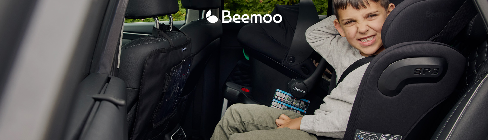 Barn i bilstol ved siden av babystol i baksetet.