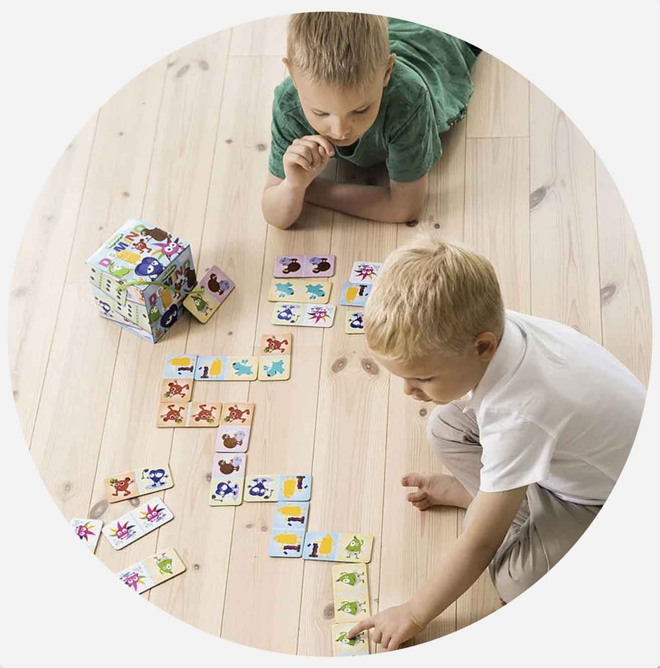 To barn leker med dyremotivkort på gulvet.