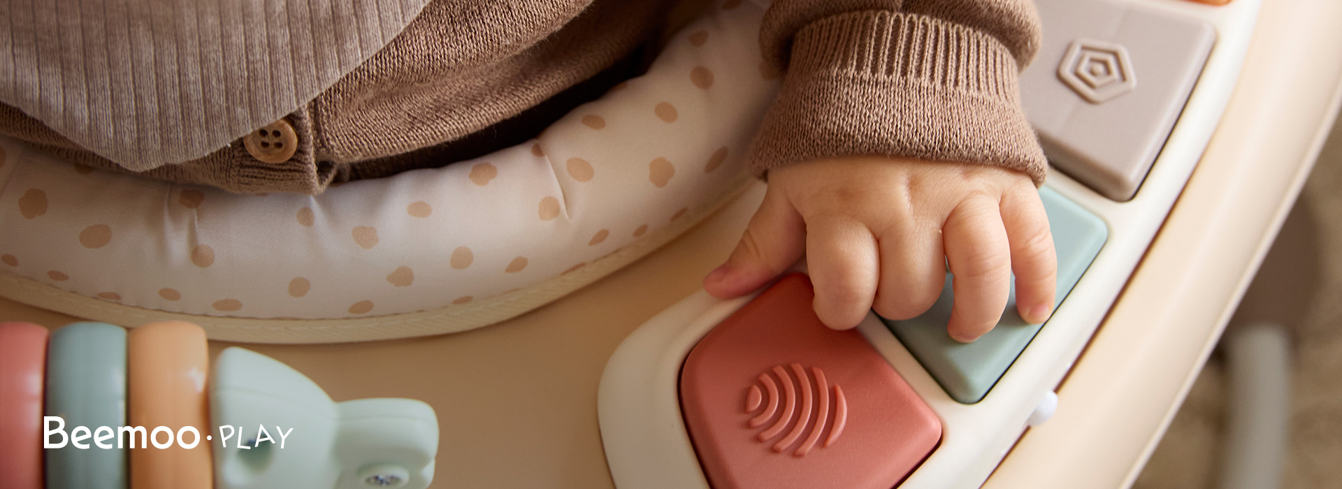 To barn leker med byggeklosser ved et bord. Beemoo Play-logo til venstre.