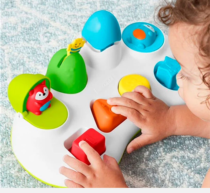 Barn leker med fargerikt aktivitetsleketøy med forskjellige former og knapper.