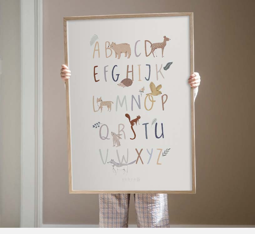 Barn holder plakat med alfabetet og dyrebilder.