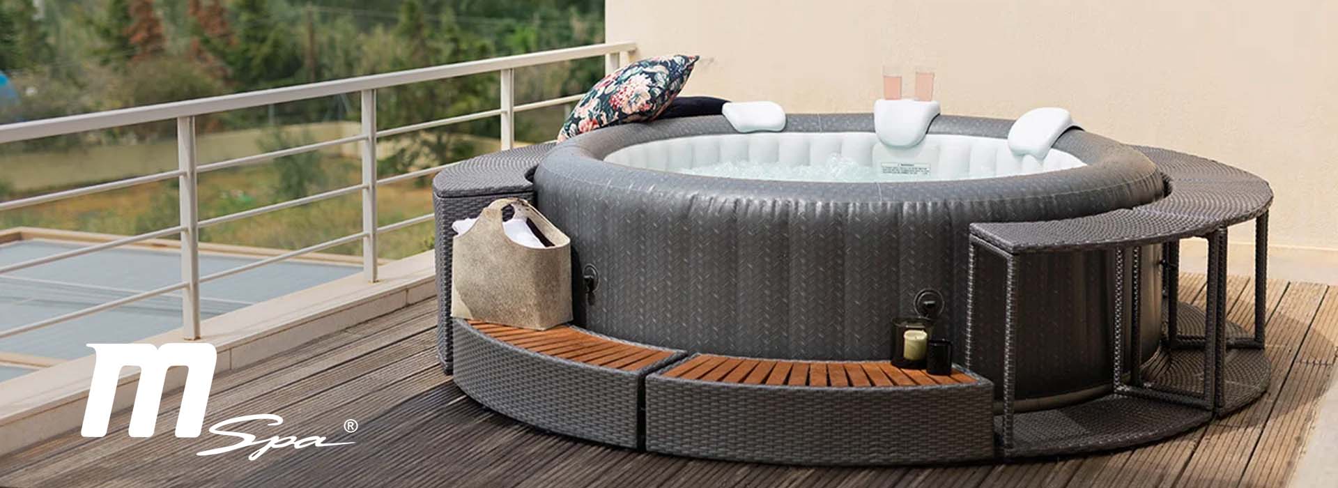 Oppblåsbart boblebad på terrasse med puter og drikke.