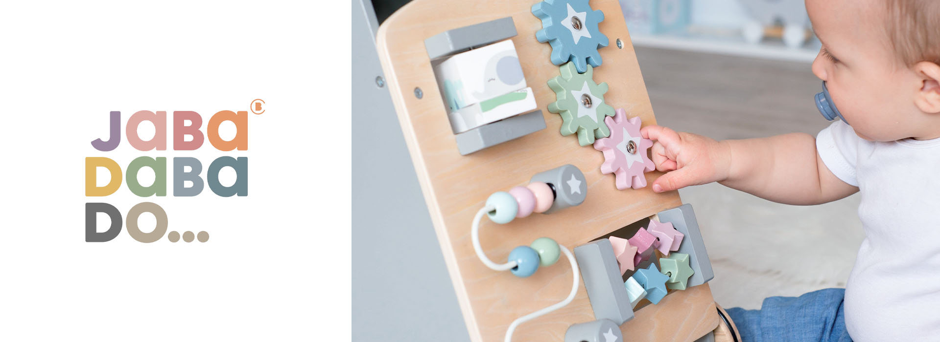 Baby leker med aktivitetstavle med tannhjul og klosser.