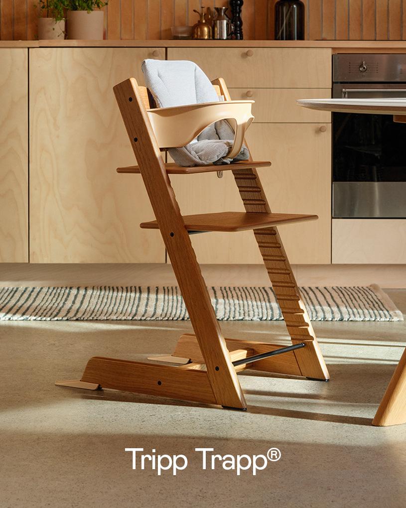 Trebarnestol med babyinnsats i kjøkkenmiljø.