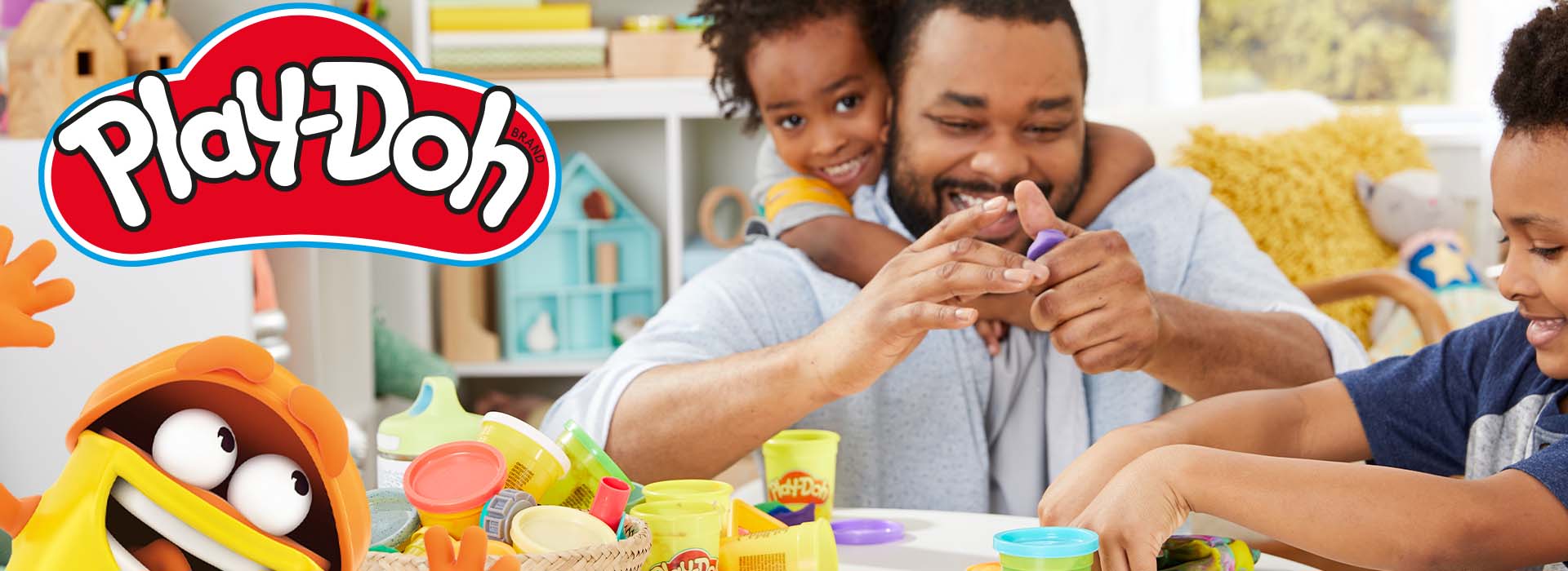 Far og barn leker med Play-Doh ved et bord.