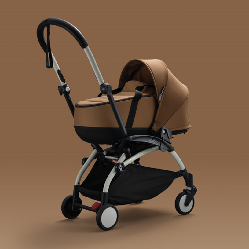 Brun barnevogn med buede håndtak på brun bakgrunn.