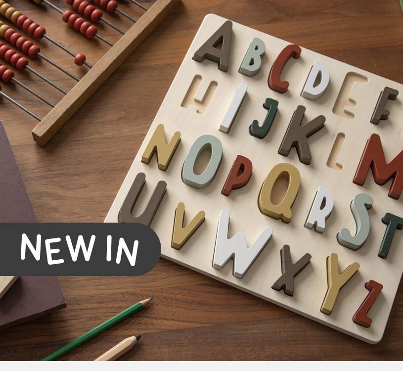 Trebrett med bokstaver og kuleramme på bord. Tekst sier "New in".