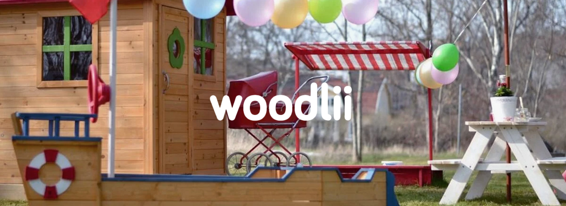 Lekestue med ballonger og trebenk i hage.