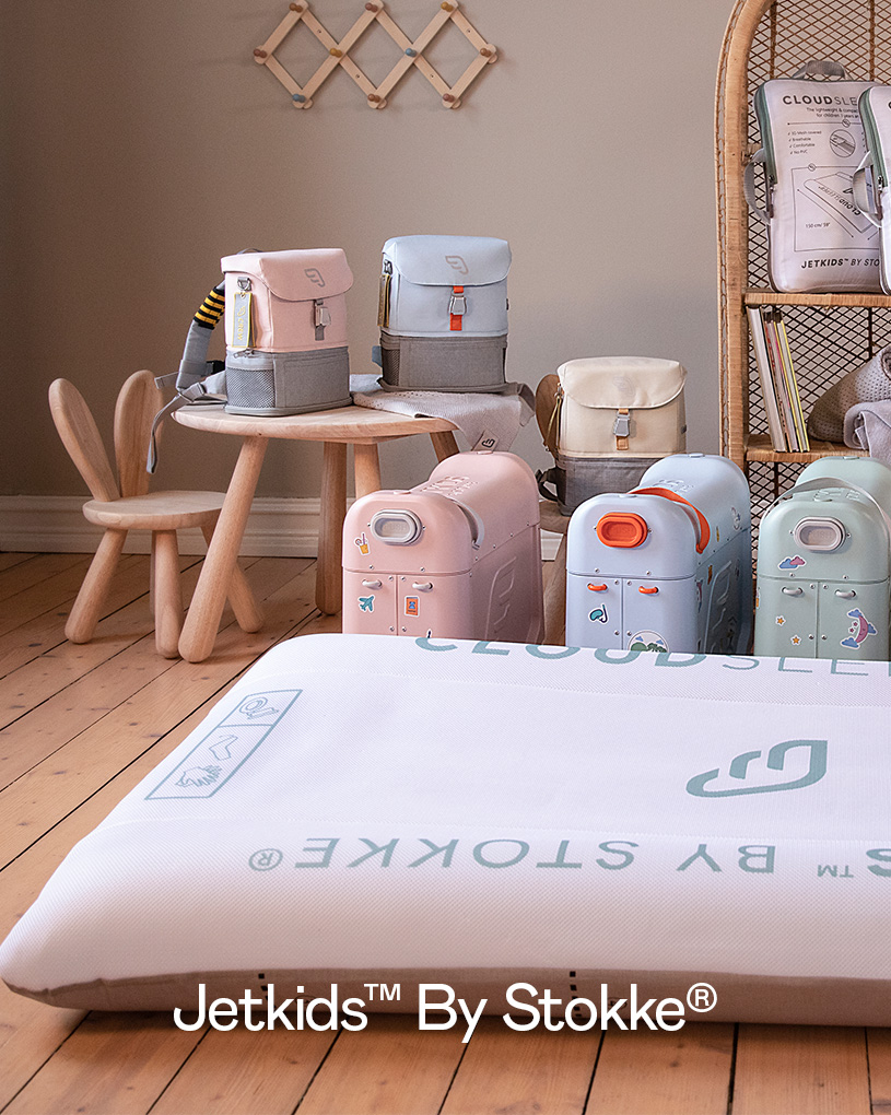 Barnemøbler og kofferter i pastellfarger i et rom.