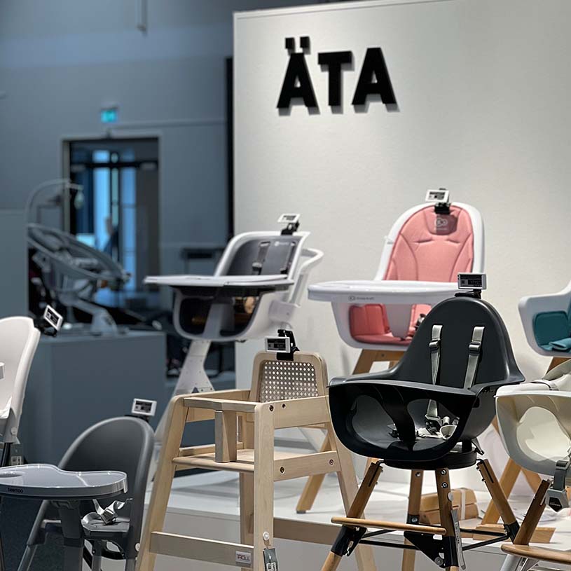 Utstilling av barnestoler i ulike farger under skiltet 'ÄTA'.