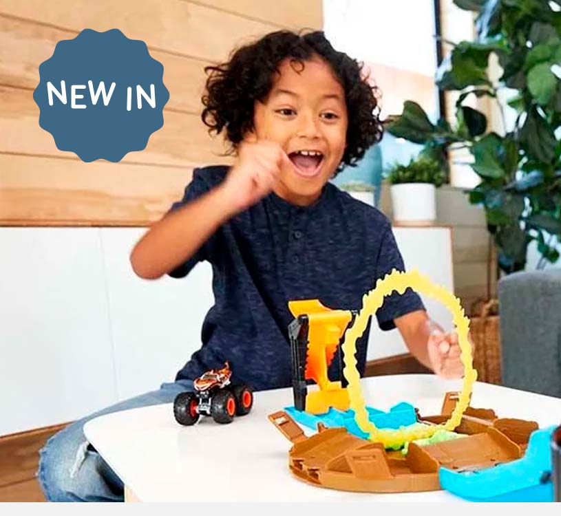 Barn leker begeistret med en lekebil og hinderløype på et bord.