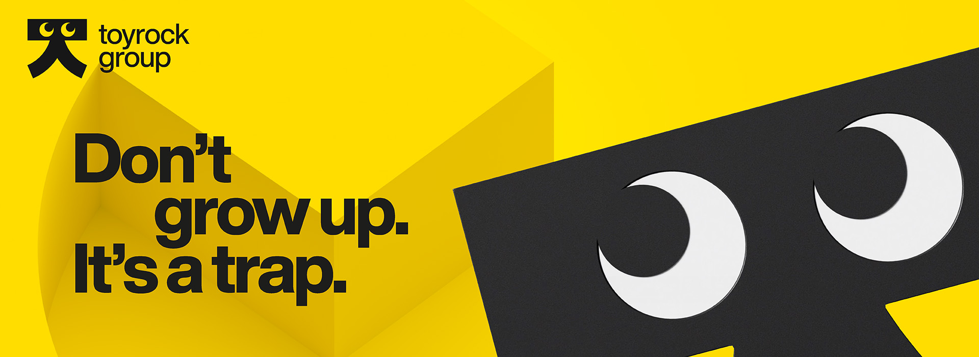 Gul plakat med teksten 'Don't grow up. It's a trap' og Toyrock Group-logoen.