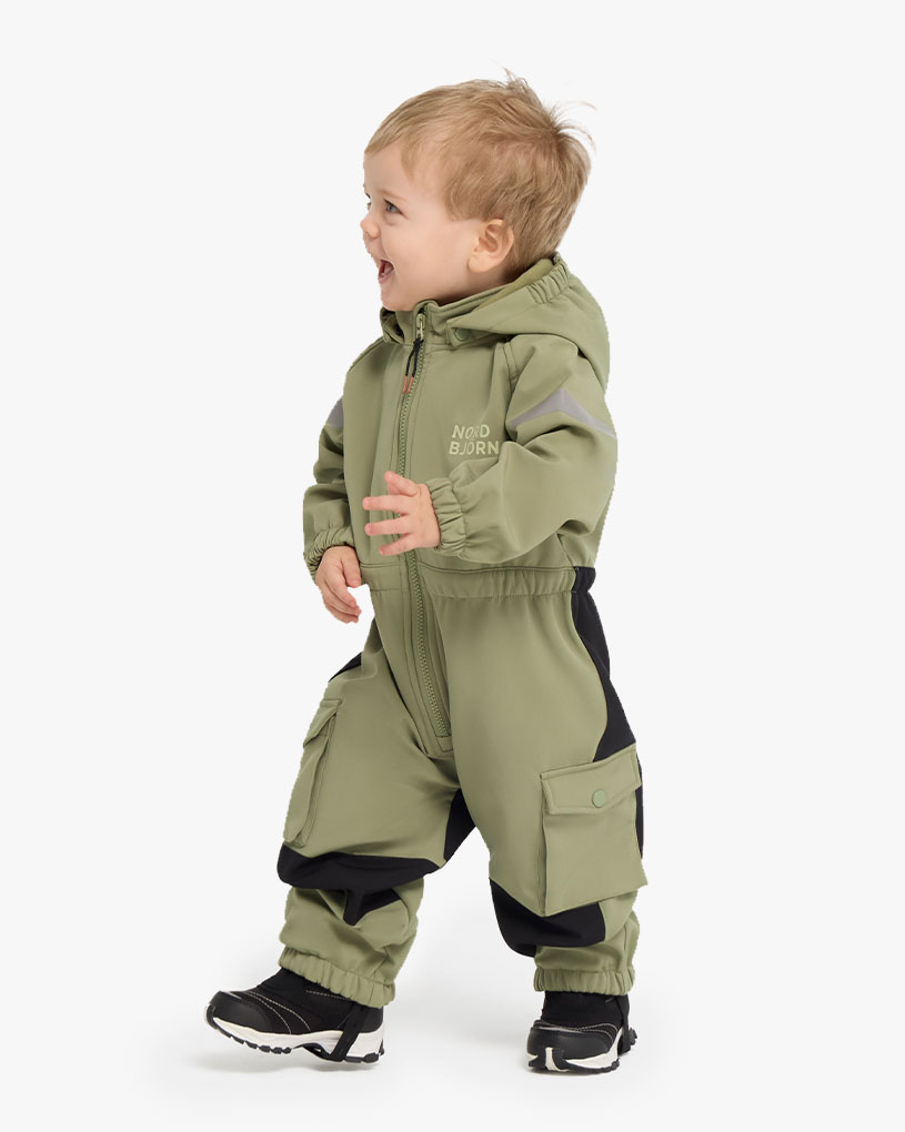 Barn i grønn jakke og rosa hatt med fletter.