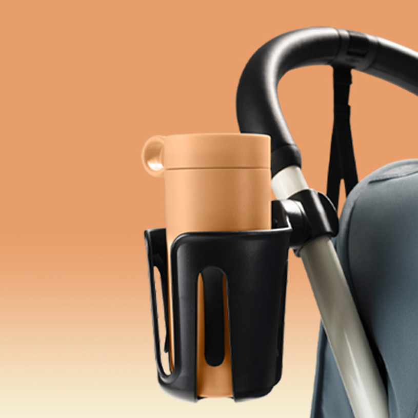 Kopp i svart holder på vogn, beige bakgrunn.