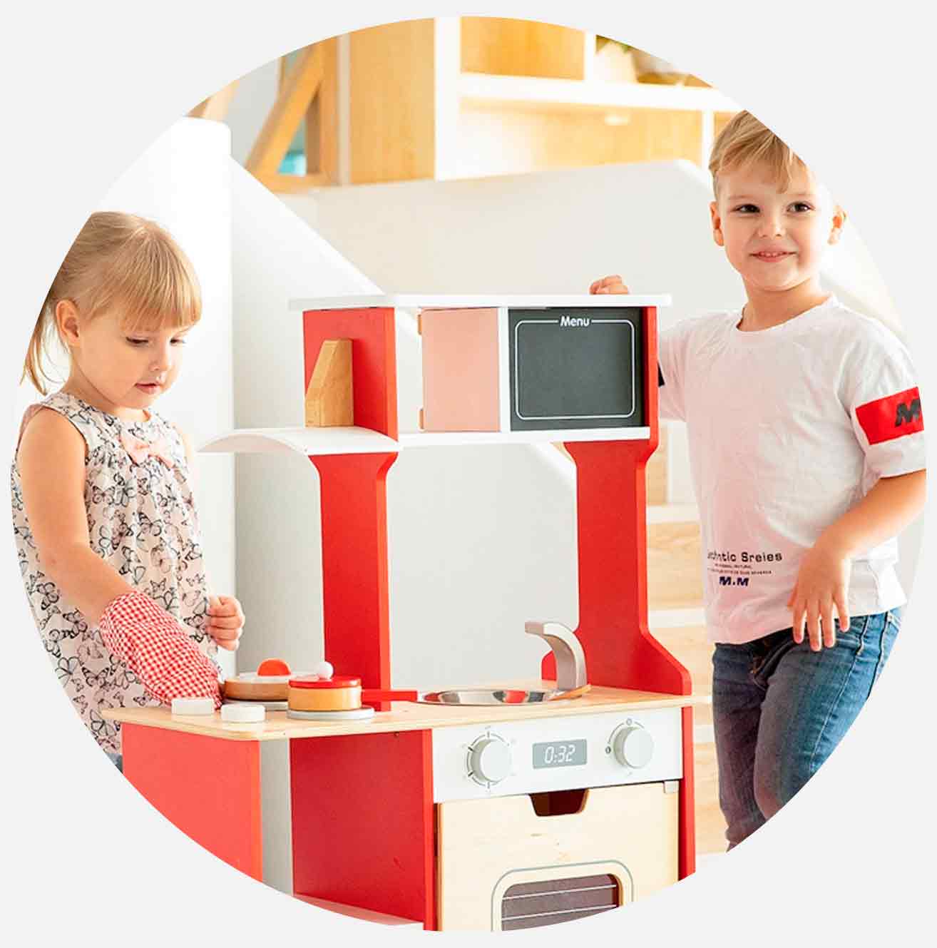 To barn leker med et rødt lekekjøkken.